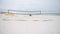 Empty volleyball field in Pensacola Beach, Gulf of Mexico in background.