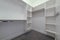 Empty walk in closet of a new home with shelves metal rods and hooks