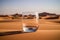 Empty water glass in desert sand drought climate change global warming concept