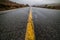 Empty wet desert asphalt pavement road with yellow highway marking lines