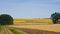 Empty wheat field after harvesting, forest band and sunflower field on a late sunny summer day, panorama photo