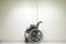 Empty wheel chair on the background of hospital wall