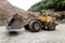 empty wheel loader machine loading gravel. Industrial machinery working with rock breaker and crusher