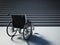 Empty wheelchair standing in front of steep staircase. 3D illustration