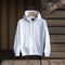 Empty white 18500 Gildan hoodie with wooden hanger on a wooden wall background. Mock up for design.