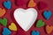 Empty white heart shaped plate and colorful jelly candies on red