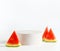 Empty white modern podium with watermelon slices at light background. Copy space for product placement. Scene stage showcase with