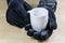 Empty white mug with gloves. Hands in warm gloves holding a chin