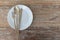 Empty white plate with spoon fork and knife on wooden table. Gold Knife, fork and spoon on white plate. Kitchen cutlery set
