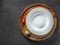 Empty white plate on wooden plate and black background with red pepper and garlic