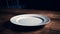 Empty white plate on wooden table