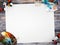 Empty white poster paper with space for mock up on wood background with color palette, paintbrush and paint colors