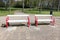 empty white and red benches stand side by side in a park