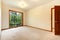 Empty white room with wood door and beige carpet.