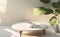 An empty white round coffee table next to a blank beige wall with morning sunlight