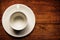 Empty white teacup and saucer on old wood texture background