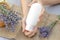 Empty white tube with lavender moisturizer in female hands. Blank for advertising