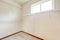 Empty white walk-in closet with beige carpet.