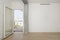 Empty white wall of apartment with exposed concrete beams with exit door