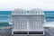 Empty white wooden beach chair on boardwalk