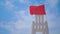 empty white wooden rescue chair on the beach with a red flag waving