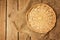 Empty wicker basket on sackcloth on wooden table background.