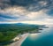 An empty wild beach, surrounded by rocks and green forests