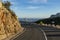 Empty winding mountain road and Calpe village at background