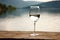 an empty wine glass on a lakeside table
