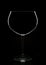 An empty wine glass in silhouette with reflection, isolated on black