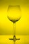 Empty wine glass on yellow background, empty wineglass