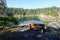 An empty wood bench overlooking a beautiful serene cove surrounded by rocky shore and forests