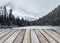 Empty wood plank on blurred snowy on pine forest with rocky mountains in Lake O\\\'hara at national park