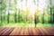 empty wood table on blur forest background for design product