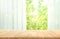 Empty of wood table top on blur of curtain with window view green from tree garden background