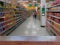 Empty wood table top on Blurred people shopping in selection of Snack on shelf in supermarket or department store, products on