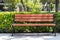 Empty wooden bench in the backyard of the campus, summer hedge, a green bush fence. Rest concept