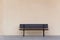 Empty wooden bench chair against blank wall