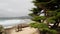 Empty wooden bench, rest on footpath trail. Ocean beach, California coast, trees
