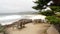 Empty wooden bench, rest on footpath trail. Ocean beach, California coast, trees