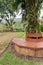 An empty wooden bench sits amidst a lush, leafy park
