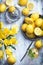 Empty wooden board with yellow flowers, lemons, squeezer and knife, with copy space