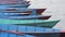 Empty wooden boats anchored at the pier swaying in the waves