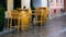 Empty wooden chairs and tables barrels on street on rainy day