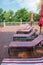 Empty wooden deck chairs with red and white striped mattresses stand in a row. Luxury outdoor recreation, vertical photo