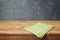 Empty wooden deck table with checked tablecloth over blackboard background