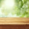 Empty wooden deck table with foliage bokeh