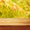 Empty wooden deck table over autumn leaves