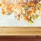 Empty wooden deck table over autumn leaves bokeh background