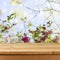 Empty wooden deck table over blooming flowers background for product montage